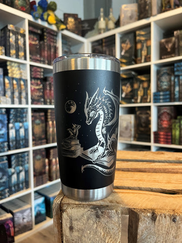 Das Produktbild zeigt einen Tumbler mit einem aufrecht sitzenden Drachen, welcher seine Klauen auf ein aufgeschlagenes Buch legt. Vor ihm ist ein Stapel Bücher, auf dem ein weiterer, kleiner Drache sitzt. Im Hintergrund ist ein kleiner Mond abgebildet.
